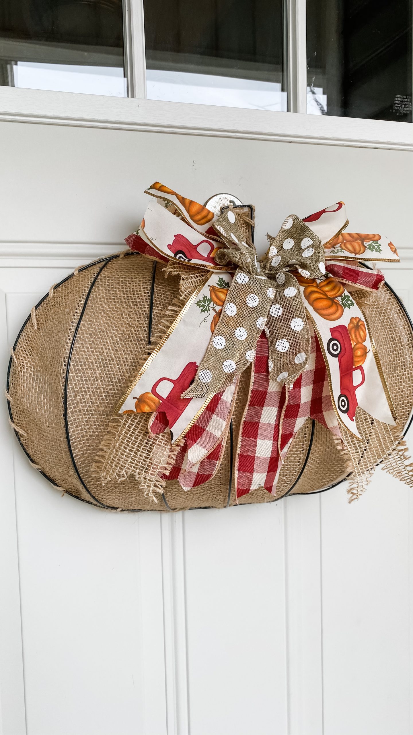 Handmade wire pumpkin door hanger displayed on the front door for fall