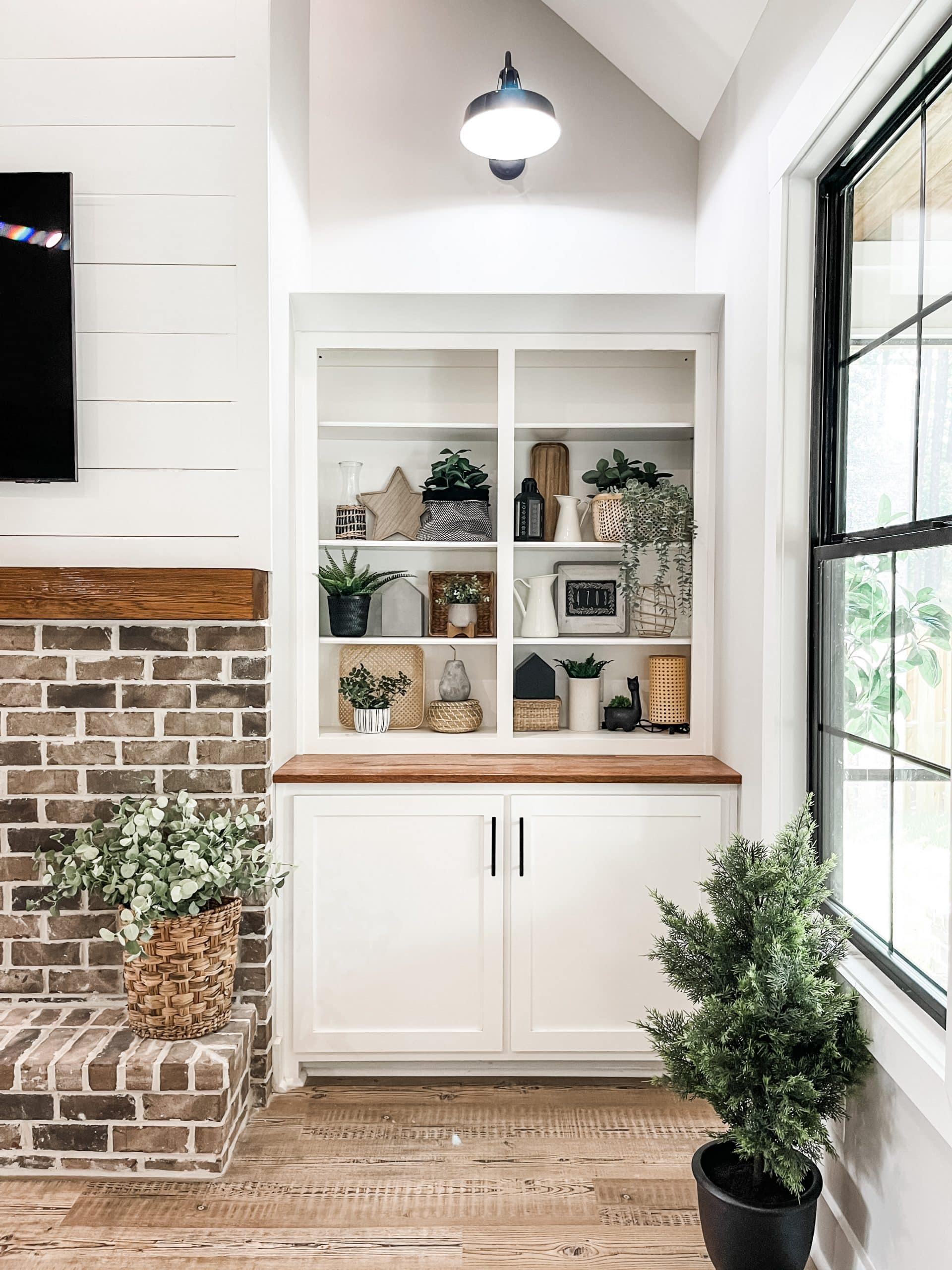 farmhouse built ins with goosneck light black windows and brick fireplace shiplap