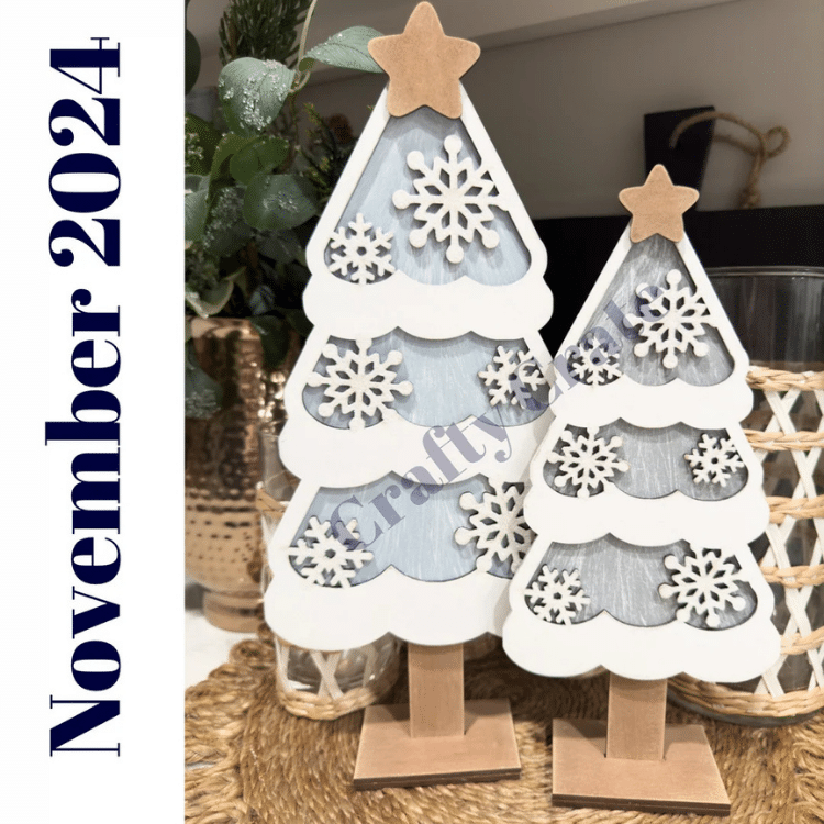 Two wooden trees with layered snow and snowflake details painted and assembled (one large and one medium)
