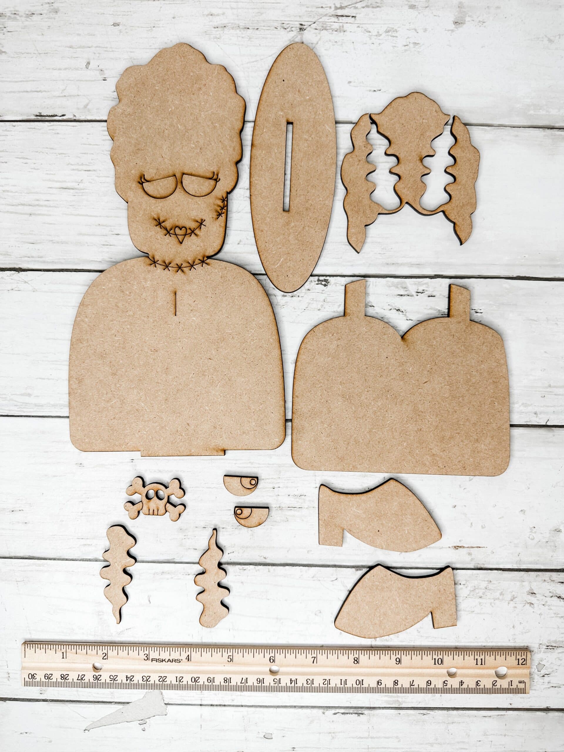 unpainted unassembled bride of frankenstein diy craft kit pieces displayed in a single layer on a neutral background