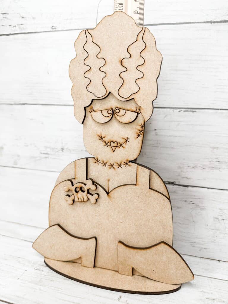 unpainted assembled bride of frankenstein diy craft kit displayed with a ruler for size reference